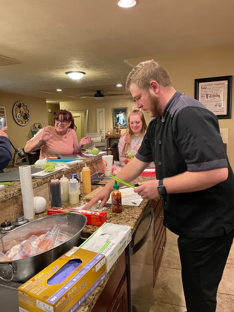 Close-up of hands shaping a sushi roll during class