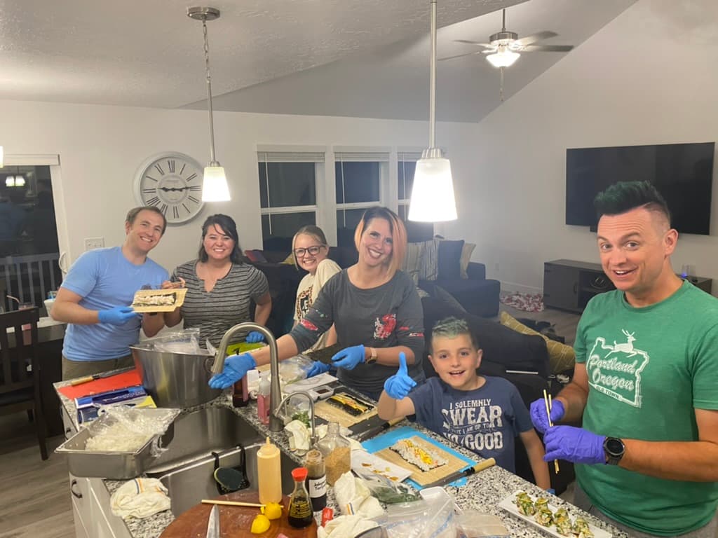 Group rolling sushi with chef guidance